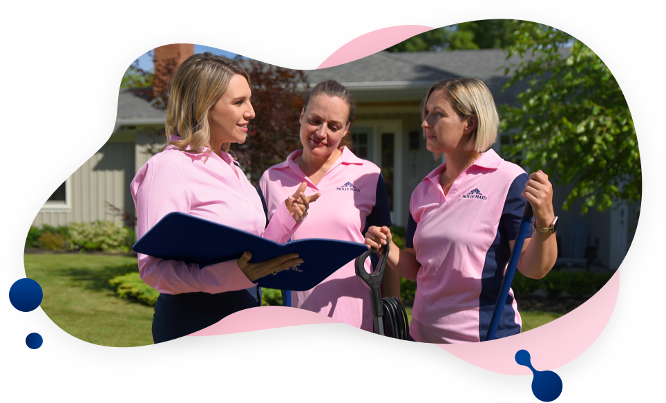 MOLLY MAID supervisor and cleaners talking outside a house